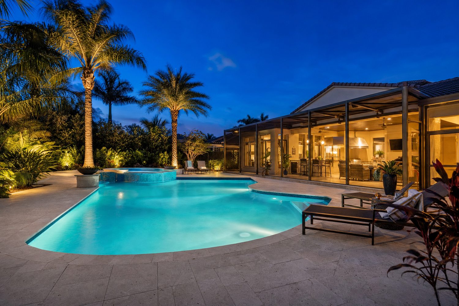 Twilight photograph of a Coral Springs pool deck with a glowing turquoise pool and uplit palms