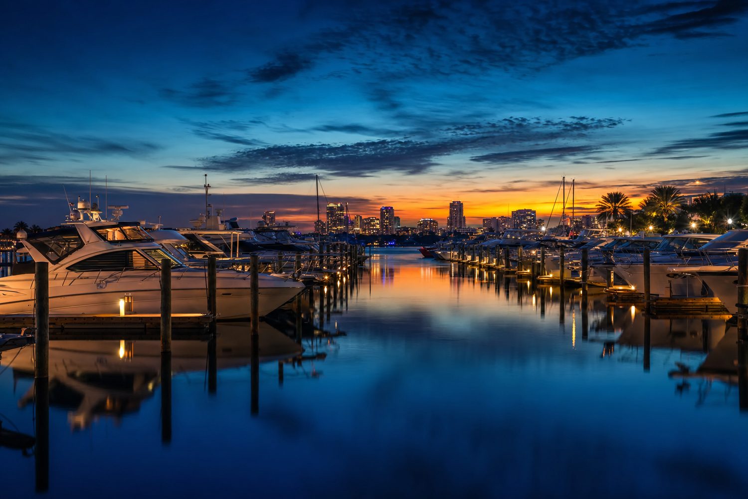 Fort Lauderdale marina at blue hour with white yachts reflecting on glassy water
